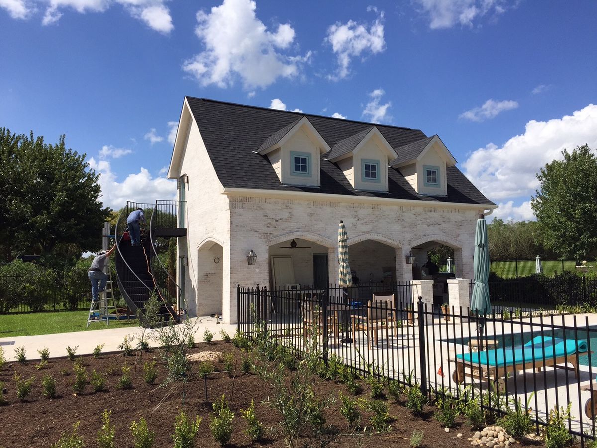 White stone pool house with arched openings and pool
