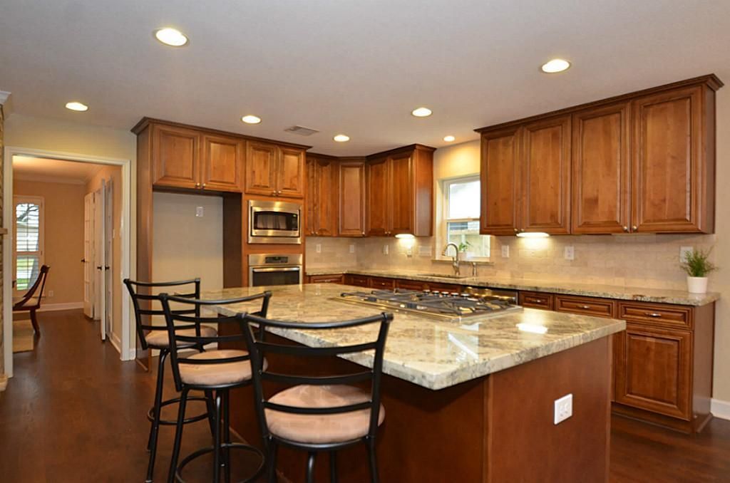 Renovated kitchen with wood cabinets and granite countertops