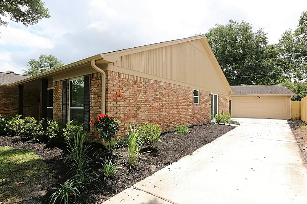 Stone and brick home with landscaping after renovation