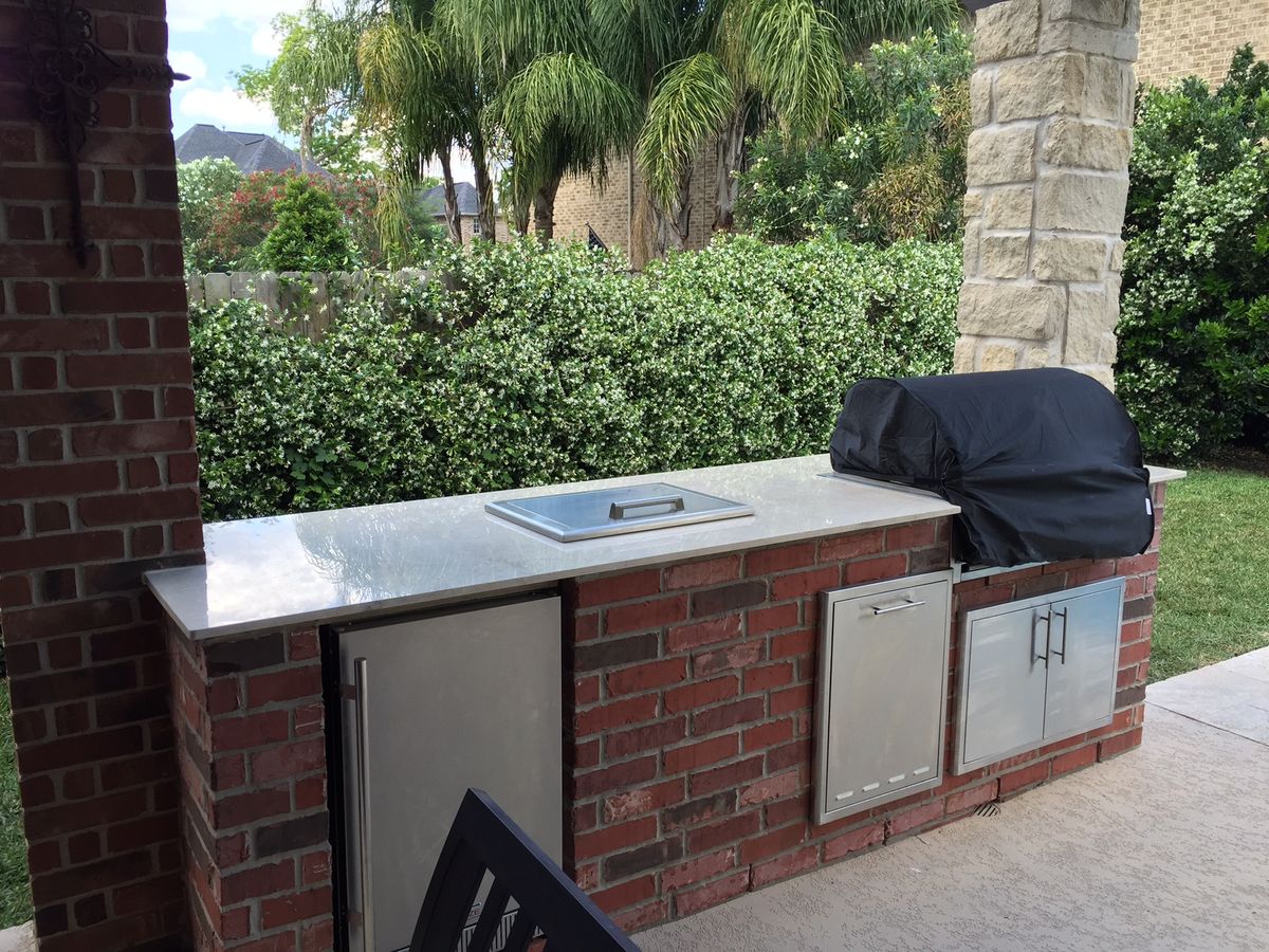 Outdoor kitchen and patio with stone fireplace